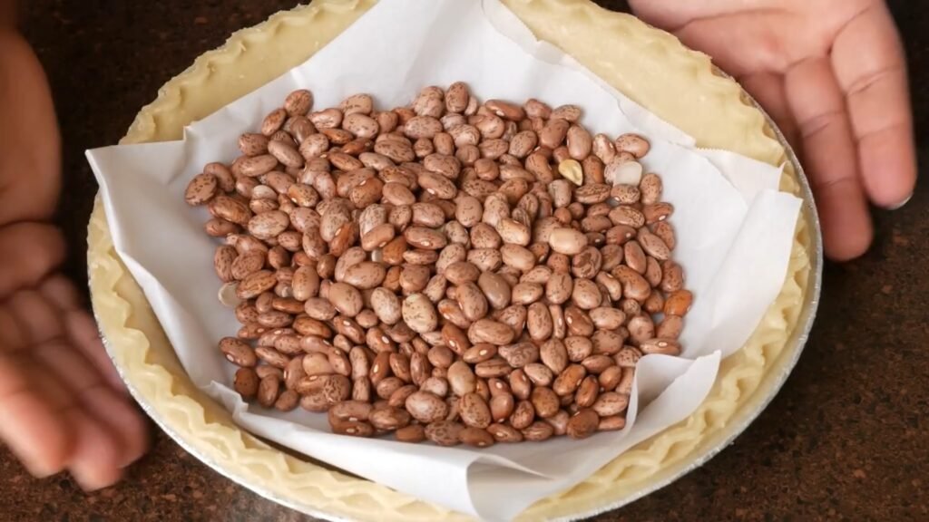 Homemade Sweet Potato Pie Recipe Preparing to blind bake pie crust using dried beans
