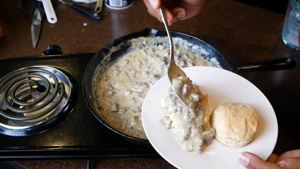 Homemade Sausage Gravy Serving sausage gravy onto biscuit