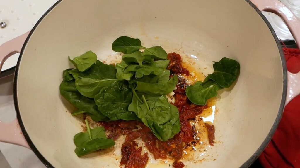 Creamy Tuscan Chicken Sautéing spinach