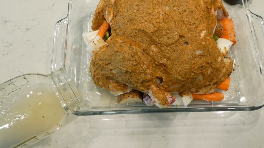 Adding broth to the roasting dish