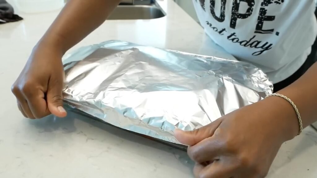Southern Baked Turkey Wings (Tender & Fall-Off-the-Bone) Roasting dish of Southern turkey wings covered with aluminum foil before baking.