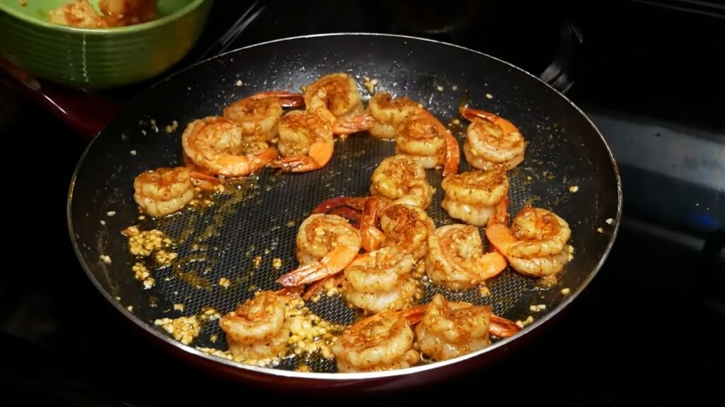Creamy Garlic Parmesan Shrimp Pasta (Ready in 15 Minutes!) Seasoned shrimp sautéing with minced garlic in a skillet almost done