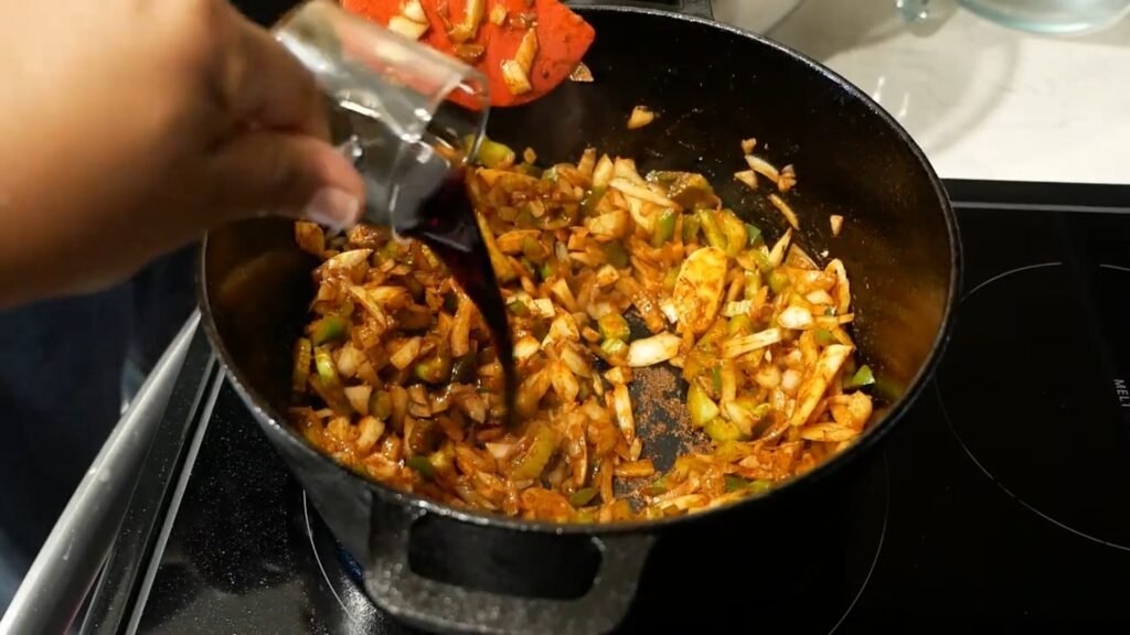 Tomato paste cooking with sautéed vegetables for braised beef shanks.